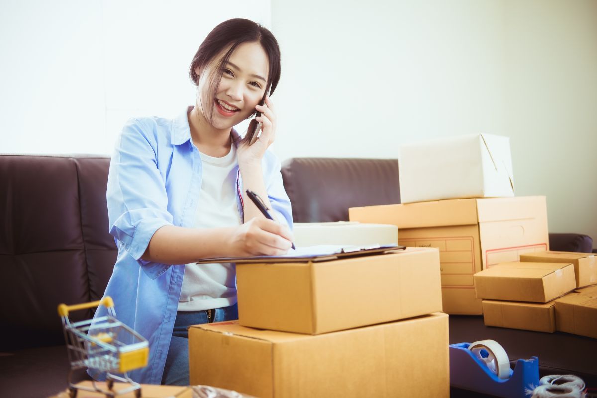 Mulher falando ao telefone, anotando pedidos, maes empreendedoras