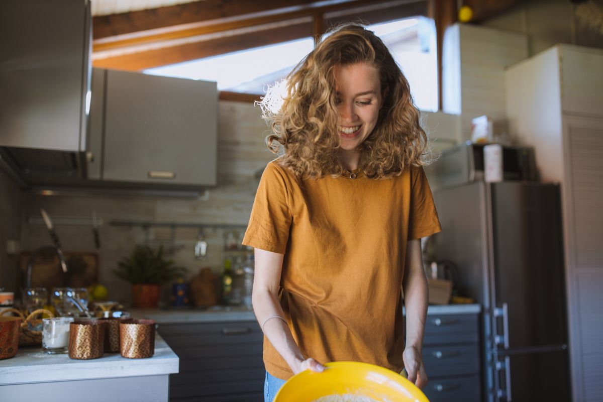 mãe sorridente preparando refeições saudáveis na cozinha,